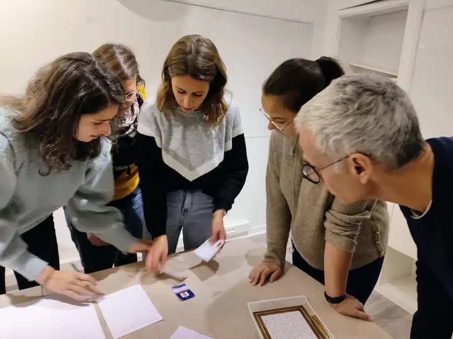 Collaborateurs qui manipulent des cartes d'énigmes pendant un escape game sur-mesure en entreprise