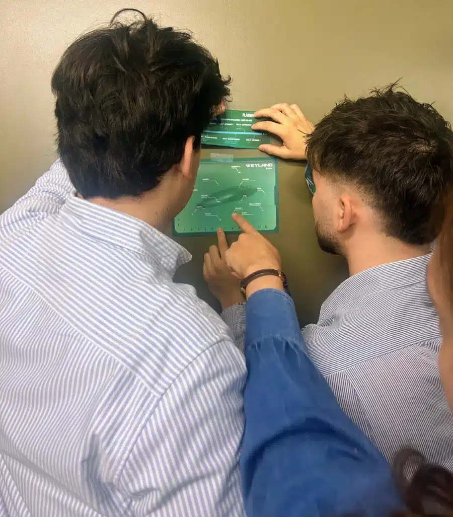 Deux collaborateurs déchiffrent un code avec un filtre transparent pendant un escape game d'entreprise