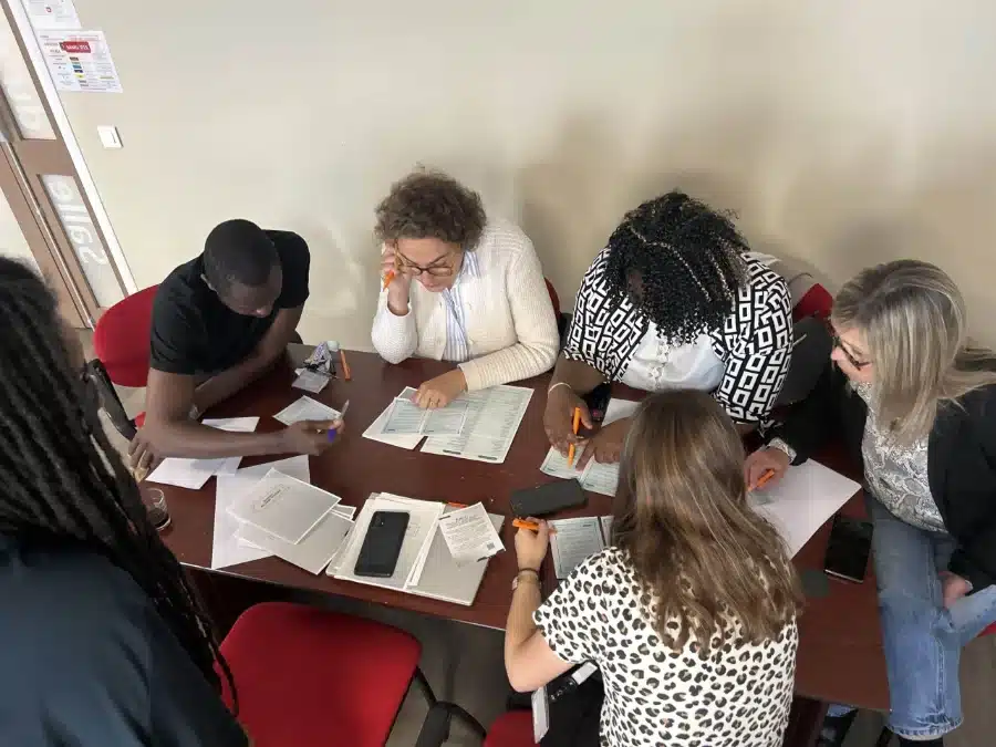 Nouveaux collaborateurs autour d'une table pendant l'escape game d'intégration conçu pour l'UGECAM